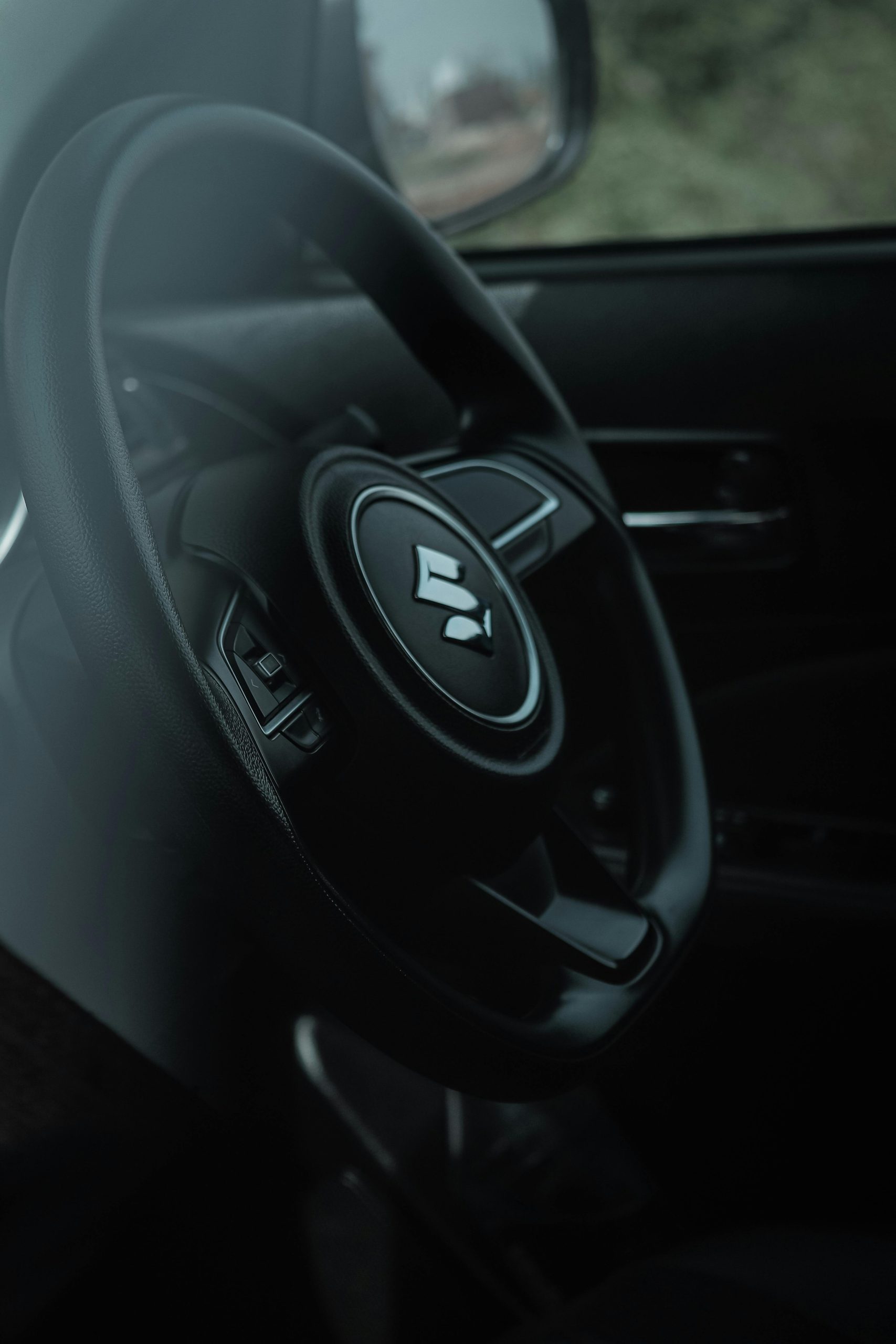 Close-up of a modern car steering wheel in a sleek interior design.